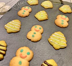 Des biscuits sablés décorés en forme de sapin de Noël et de bonhomme de neige