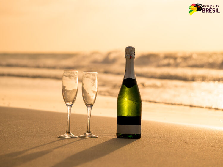 Une bouteille de champagne et 2 coupes sur le sable de la plage