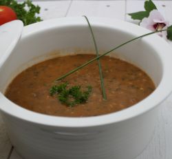 Bol de soupe aux haricots et chorizo avec décoration de ciboulette et persil