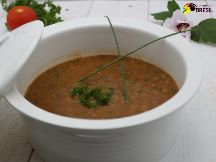 Grand bol de soupe aux haricots décorée avec de la ciboulette et du persil