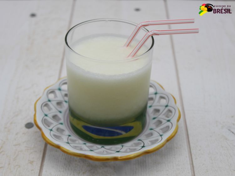 Jus de melon servi dans un verre avec le fond décoré par un drapeau du Brésil et des pailles