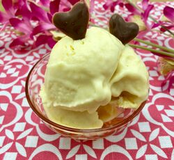 Une coupe de crème glacée à la mangue décorée avec 2 cœurs en chocolat