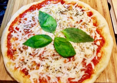 Pizza au fromage avec sauce tomate et feuilles de basilic cuite à la poêle