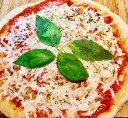 Pizza au fromage avec sauce tomate et feuilles de basilic cuite à la poêle